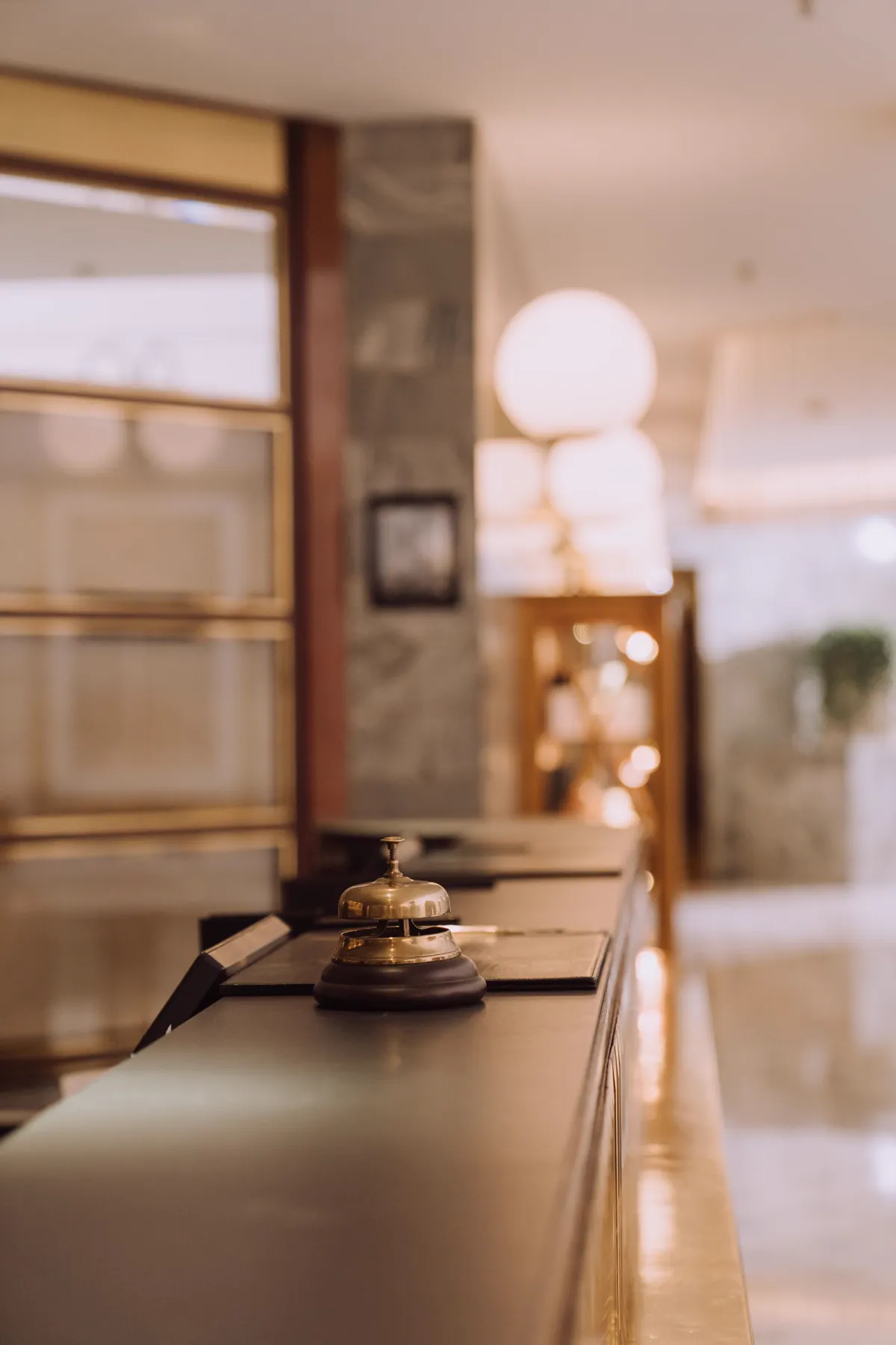 Campana de recepción de hotel sobre un mostrador en penumbra